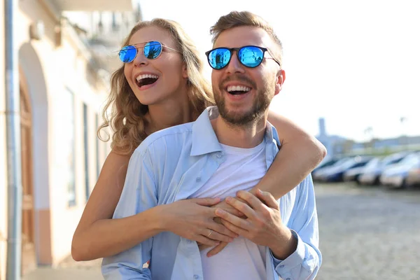 Hermosa pareja joven enamorada caminando al aire libre en la calle de la ciudad, abrazándose — Foto de Stock