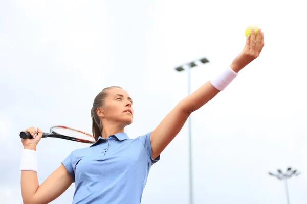 Beautiful tennis player serving the ball on the tennis court.