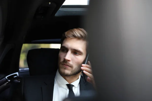 Tankeväckande säker affärsman pratar i telefon när du sitter i bilen. — Stockfoto