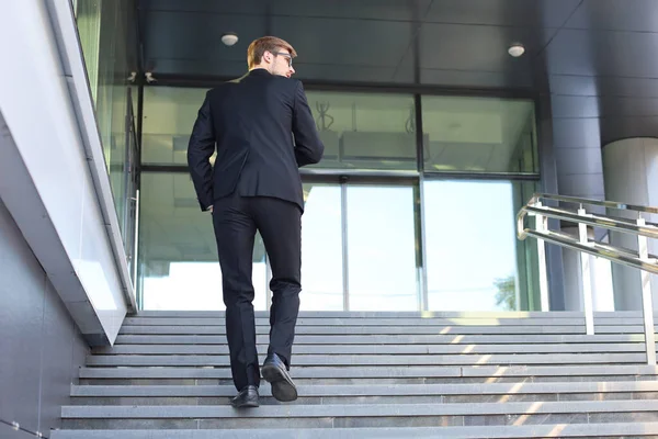 Stijlvolle succesvolle zakenman gaat de trap van het kantoorgebouw op. — Stockfoto