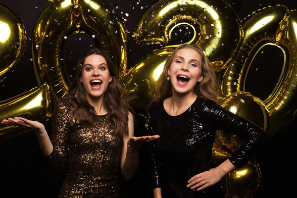 Happy gorgeous girls in stylish sexy party dresses holding gold 2020 balloons, having fun at New Year 's Eve Party . — стоковое фото