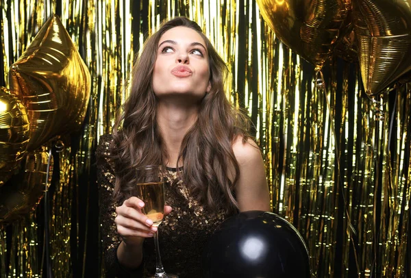 Веселая женщина с воздушными шарами смеется на золотом фоне . — стоковое фото