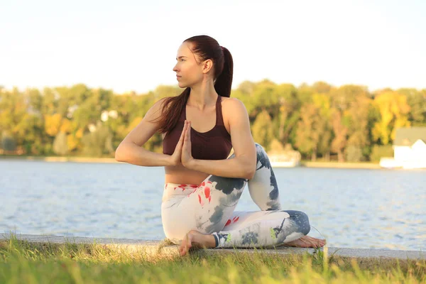 Young pretty woman doing yoga exercises in the park. — 스톡 사진