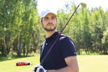 Adam güzel güneşli yeşil golf sahasında golf oynuyor
