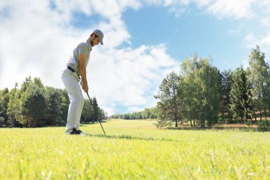Güneşli bir günde golf oynayan golf oyuncusu tam uzunlukta. Profesyonel erkek golfçü golf sahasında çekim alarak