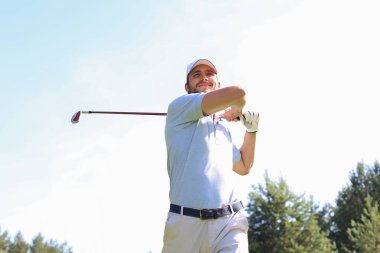 Golfçü yaz tatilinde golf sahasında golf sahasını vuruyor.