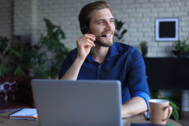 Konsantre genç serbest çalışan işadamı video konferansı için dizüstü bilgisayar kullanıyor, evde uzaktan çalışıyor.