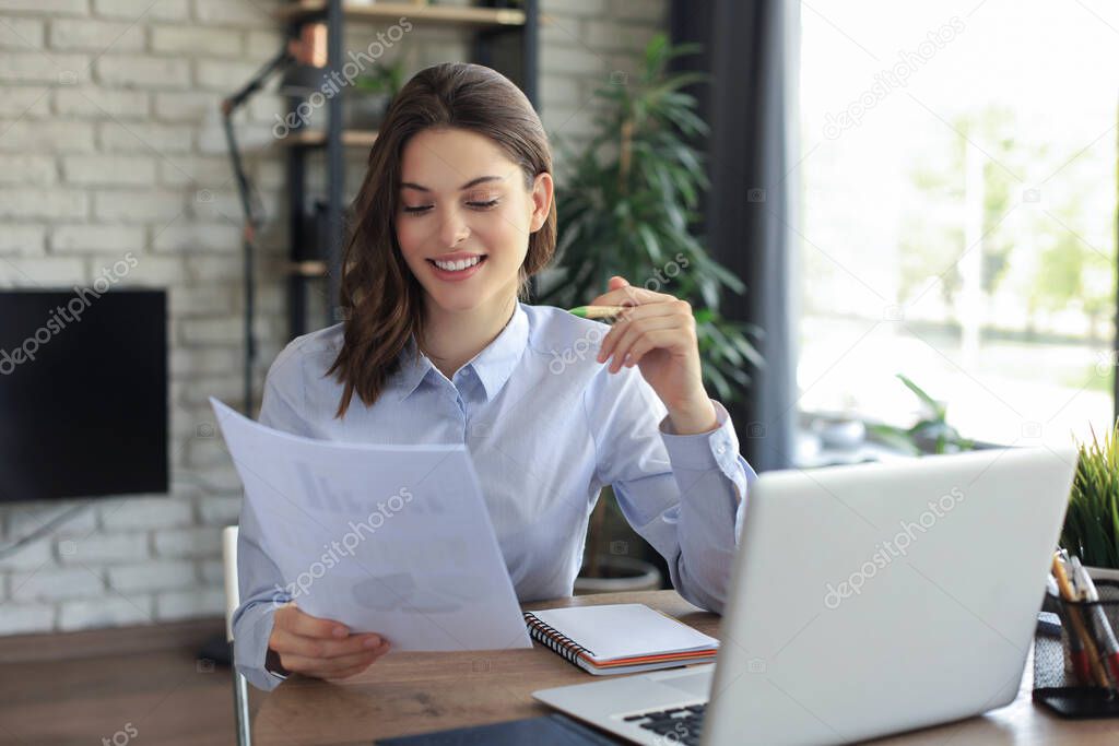 Happy entrepreneur woman sit at desk reading good news in post paper correspondence