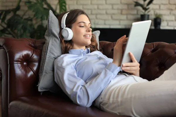 Smiling Young Woman Headphones Digital Tablet Sofa — Stock Photo, Image