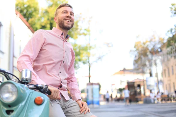 ハンサムな男が休暇のコンテキストでスクーターでポーズします ストリート ファッションとスタイル — ストック写真
