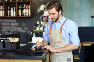 Kafesinde çalışan küçük bir işletme sahibi.