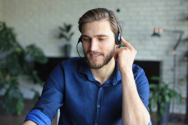 Confident man wearing headset speaking and watching business webinar training, listening to lecture. — Stock Photo, Image