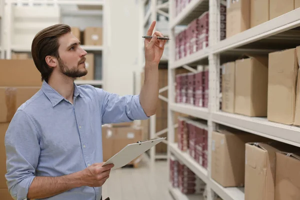 Manager gebruikt zijn tablet voor online controle producten beschikbaar. — Stockfoto