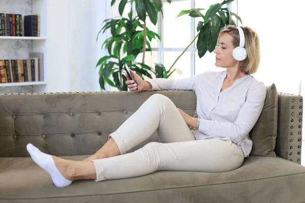 Mulher Meia Idade Bonita Relaxando Sofá Usando Smartphone Fones Ouvido — Fotografia de Stock