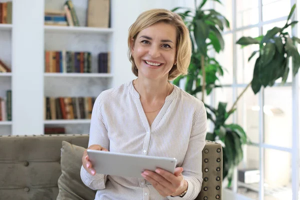 Allegro Donna Mezza Età Seduta Sul Divano Utilizzando Applicazioni Tablet — Foto Stock