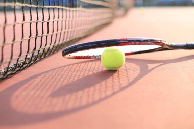 Tenis raketi ve tenis kortunda top.