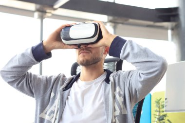 Genç adam oyun kulübünde sanal gerçeklik kulaklığı kullanarak oyun oynuyor.