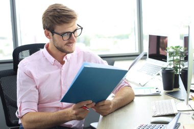 Başarılı girişimci dikkatli ve yoğun bakışla belgeleri inceliyor..