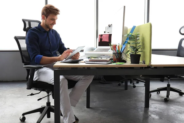 オフィスに座っている間 デジタルタブレットを使用して働いている若い現代のビジネスマン — ストック写真