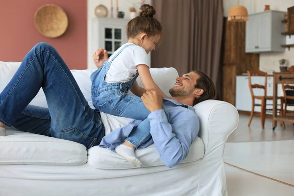 Sonriente Joven Padre Acostado Sofá Sala Estar Jugar Con Pequeña —  Fotos de Stock