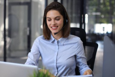 Kulaklıklı ve gülümseyen kadın müşteri destek operatörü