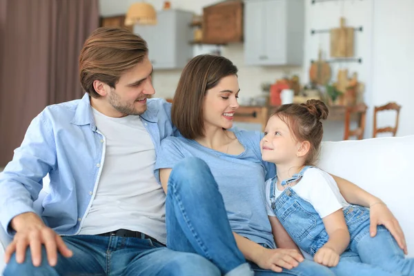 Padres Jóvenes Amistosos Positivos Con Una Hijita Sonriente Sentada Sofá —  Fotos de Stock