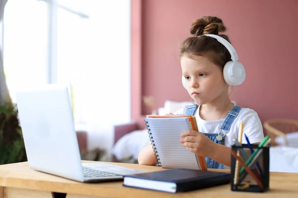 Niña Con Auriculares Sentada Escritorio Escribiendo Cuaderno Estudiando Línea Hacer Fotos de stock libres de derechos