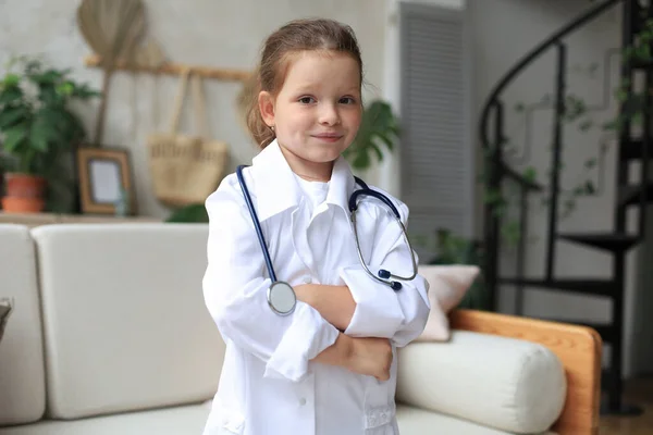 Sorridente Bambina Uniforme Medica Che Gioca Con Stetoscopio Casa — Foto Stock