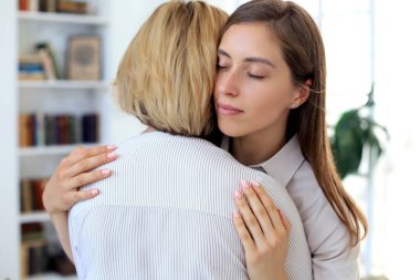 Endişeli orta yaşlı anne ve yetişkin kız kanepede oturup ciddi konuşmalar yapıyor, paylaşım sorunlarını dinliyor..