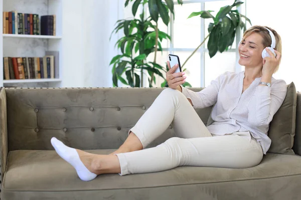 Hermosa Mujer Mediana Edad Que Relaja Sofá Usando Teléfonos Inteligentes —  Fotos de Stock