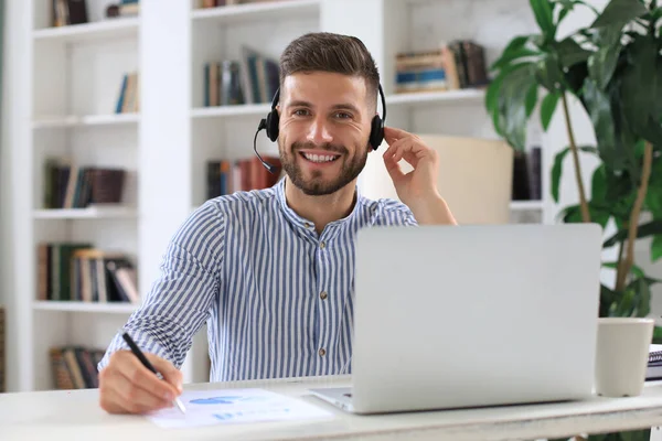 Nachdenklicher Junger Geschäftsmann Schreibt Etwas Auf Während Modernen Büro Arbeitet — Stockfoto