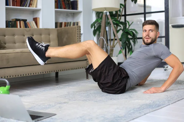 隔離中に自宅で腹筋運動をするハンサムな男 健康的な生活の概念 — ストック写真