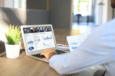 İş adamı video konuşmasında iş arkadaşlarıyla kişisel izolasyon ve karantina sırasında online brifing hakkında konuştu. Şirketlerinin mali raporlarını tartışmak için evde dizüstü bilgisayarla çalışan bir iş ekibi.