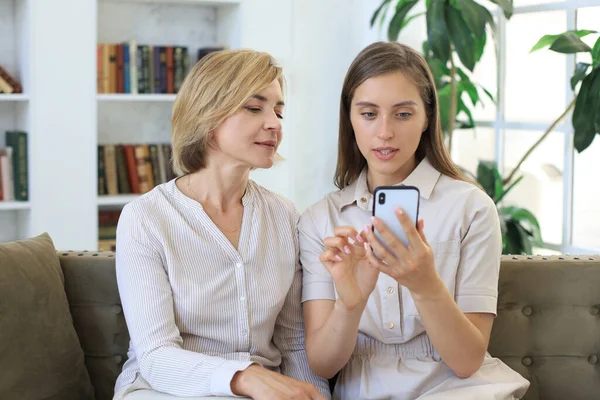 Madre Mediana Edad Hija Adulta Abrazándose Usando Teléfono Juntos Viendo —  Fotos de Stock