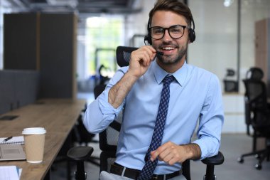 Gülümseyen yakışıklı genç erkek çağrı merkezi operatörü