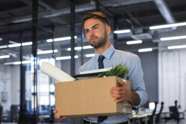 Üzgün işçi ofis malzemelerini yanında götürüyor.
