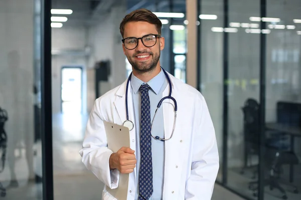 Knappe Vriendelijke Jonge Dokter Ziekenhuisgang Kijkend Naar Camera Glimlachend — Stockfoto