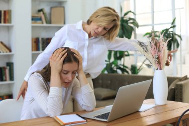 Dizüstü bilgisayarla çalışan ve yeni projeyi tartışan iki kız öğrenci.