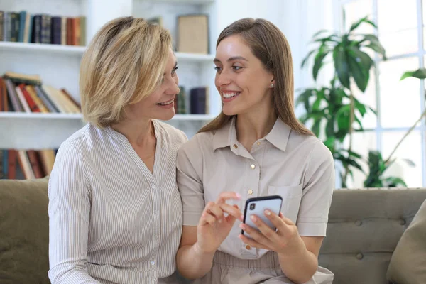 Madre Mediana Edad Hija Adulta Abrazándose Usando Teléfono Juntos Viendo —  Fotos de Stock