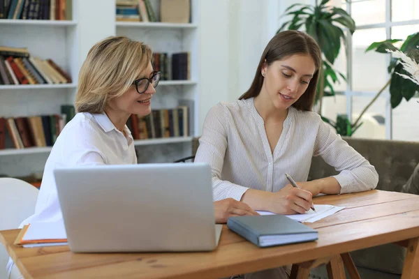 Beautiful businesswoman work together sitting on the table in office