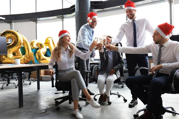 Gli uomini d'affari festeggiano le vacanze nel moderno ufficio bevendo champagne e divertendosi nel coworking. Buon Natale e Felice Anno Nuovo 2021. — Foto Stock