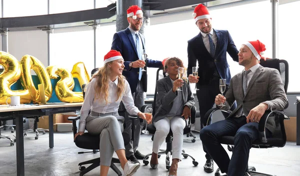 Pessoas de negócios estão comemorando férias no escritório moderno bebendo champanhe e se divertindo em co-working. Feliz Natal e Feliz Ano Novo 2021. — Fotografia de Stock