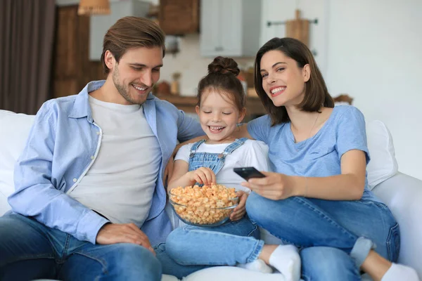 Família Feliz Com Criança Sentada Sofá Assistindo Comendo Pipocas Jovens — Fotografia de Stock