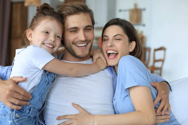 Padres Jóvenes Amistosos Positivos Con Una Hijita Sonriente Sentada Sofá — Foto de Stock