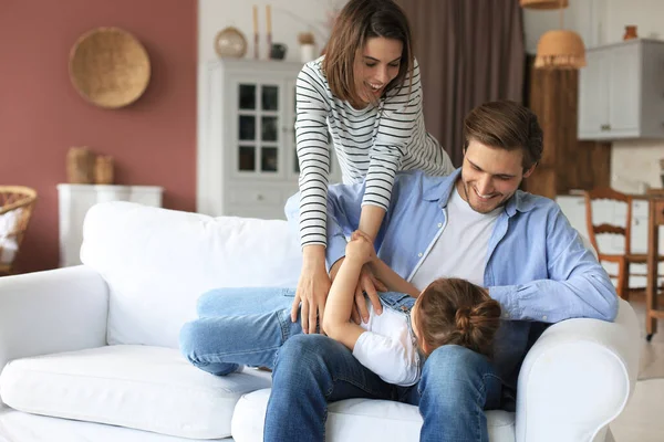 Padres Jóvenes Amistosos Positivos Con Una Hijita Sonriente Sentada Sofá —  Fotos de Stock