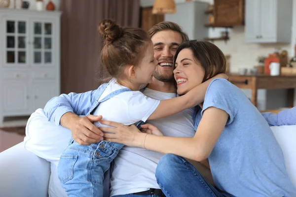 Positivos Pais Jovens Amigáveis Com Pequena Filha Sorridente Sentada Sofá — Fotografia de Stock