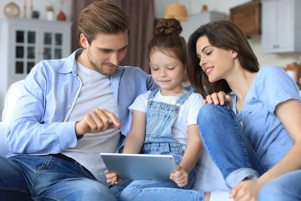 Pais Jovens Amigáveis Positivos Com Pequena Filha Sorridente Sentada Sofá — Fotografia de Stock