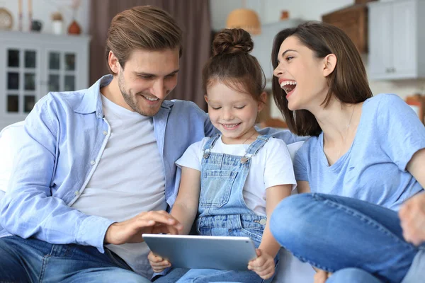 Pais Jovens Amigáveis Positivos Com Pequena Filha Sorridente Sentada Sofá — Fotografia de Stock