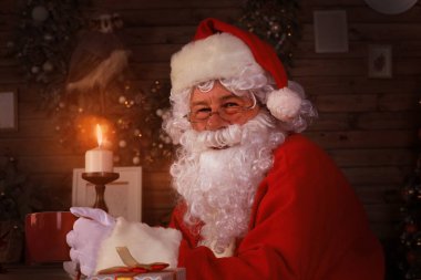 Noel Baba evdeki şöminenin yanındaki rahat koltukta dinleniyor..