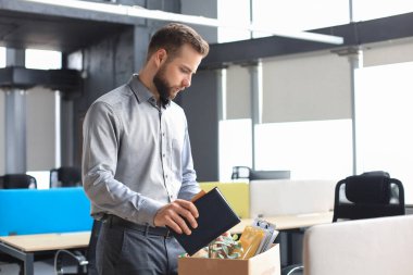 Üzgün işçi ofis malzemelerini yanında götürüyor.